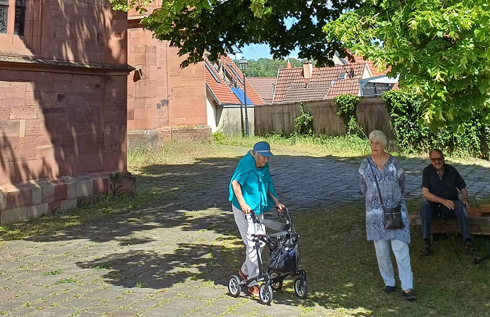 Senioren spazieren vor den besuchten Gebäuden