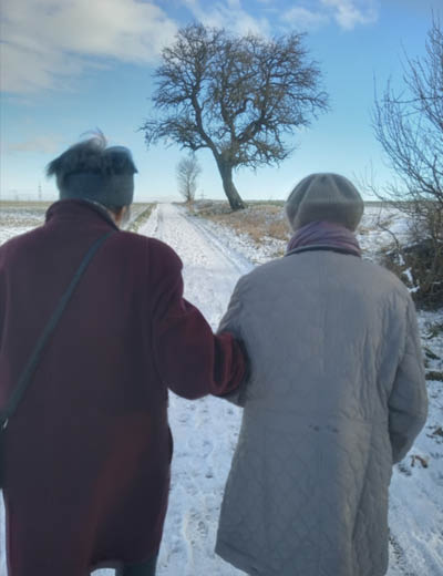 Senioren gehen spazieren in Winterlandschaft